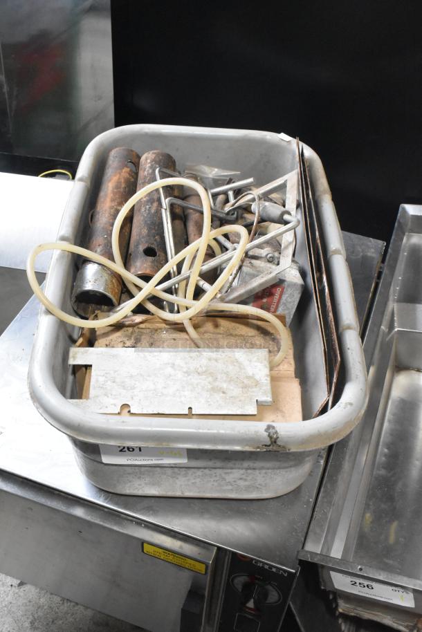 Lot of various metal pieces in a bin, includes tubes and hoses, condition visible as worn. Auction label reads "261."