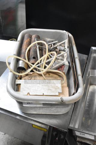 Lot of various metal pieces in a bin, includes tubes and hoses, condition visible as worn. Auction label reads "261."