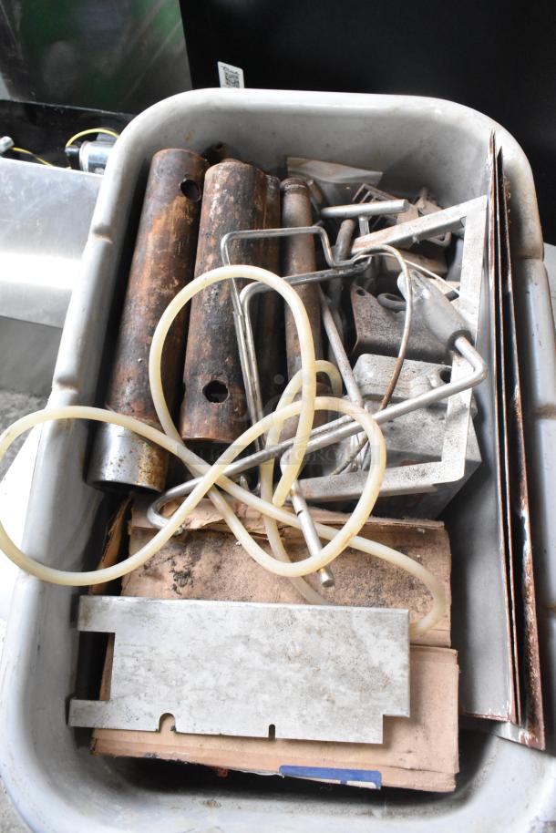 Lot of various metal items in a bin, includes rods, tubing, and plates; mixed condition, showing rust and wear.