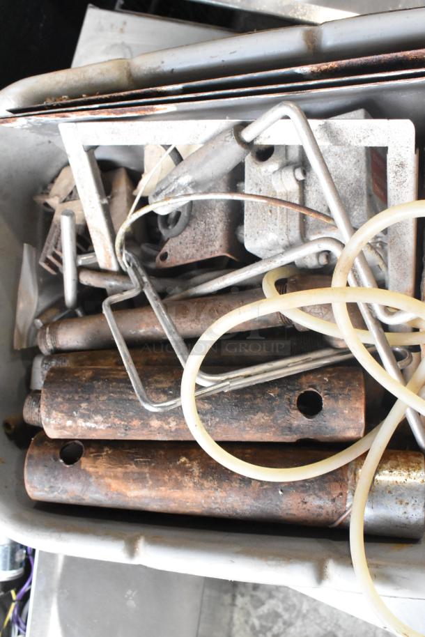 Lot of various metal pieces in a bin, featuring rods, pipes, and wires. Rusty condition, ideal for scrap or parts.