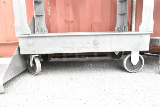 Gray poly 2-tier cart with commercial casters, durable design, slightly worn, used for heavy-duty transport.