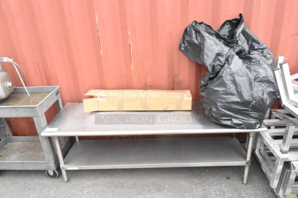 Stainless steel equipment stand with metal under shelf, sturdy condition, featuring top work surface, ideal for industrial use.