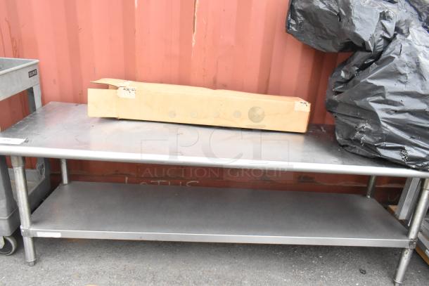 Stainless steel equipment stand with metal under shelf, showing slight surface wear, suitable for industrial use.