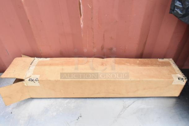 Cardboard box containing stainless steel equipment stand with metal under shelf. Box shows slight wear. No visible labels or markings.