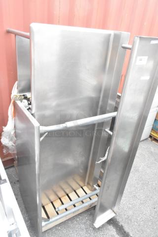 Three stainless steel tables, stacked, in good condition. Visible item tag "322". Auction lot offers 3 times your bid.