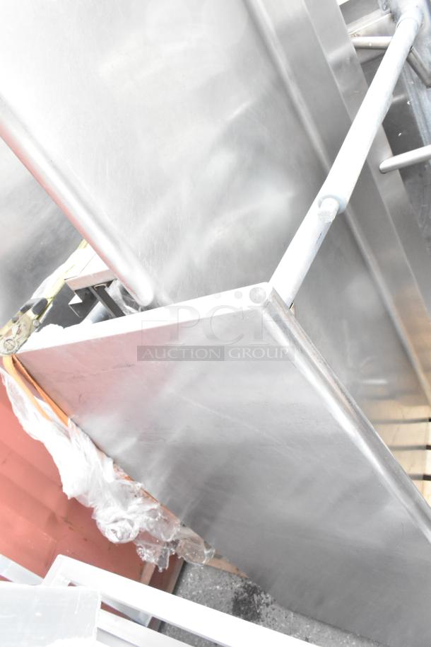 Three stainless steel tables stacked, showcasing their polished surface; ideal for industrial or commercial use.