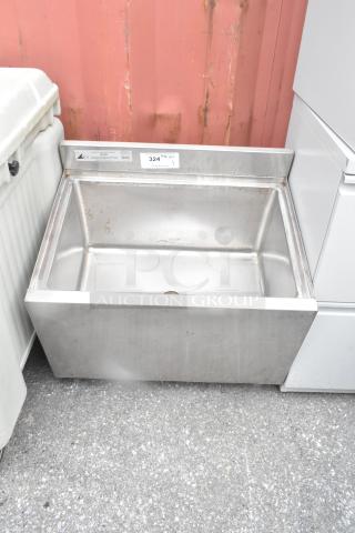 Stainless steel commercial ice bin without legs, features drain hole, visible sticker indicating model KCS, minor surface wear.