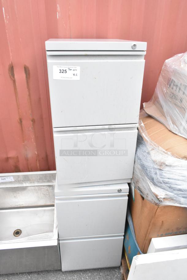 Two gray metal 2-drawer filing cabinets, minor wear, auction tag "325" visible. Sturdy and functional, ideal for office storage.