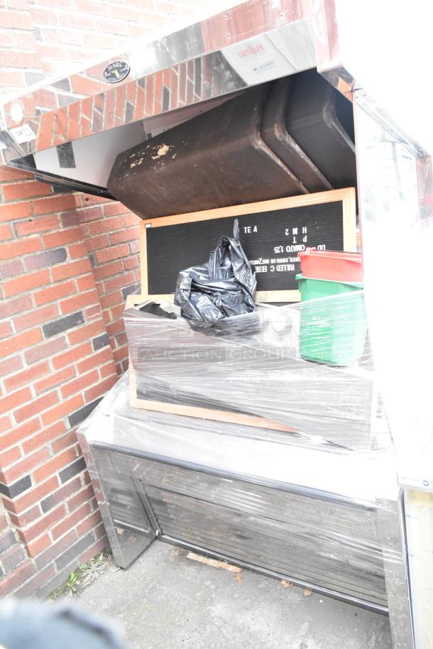 Marc Metal Commercial Open Grab N Go Merchandiser, wrapped, with assorted contents. Metal exterior shows visible wear.