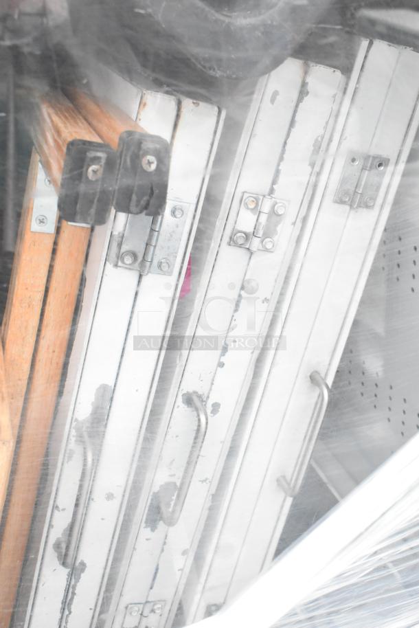 Marc Metal Commercial floor-style open merchandiser with contents; visible metal frames and hinges; used condition.