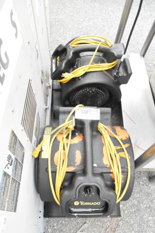 Two Tornado 98774 air mover fans, 120V, used condition, with attached yellow power cords. Labels and markings visible.
