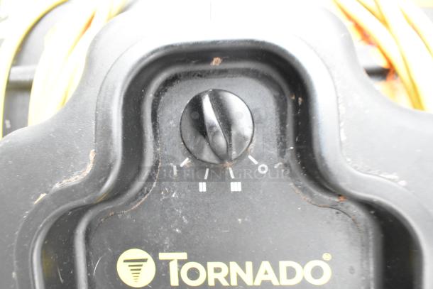 Tornado 98774 air mover fan, black control dial, speed settings visible, 120V, 1 phase. Yellow cord behind, worn edge.
