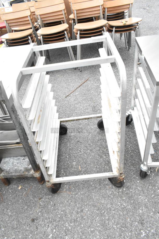 Metal bun sheet pan rack on commercial casters, sturdy frame, visible wear. Ideal for bakery or kitchen use.