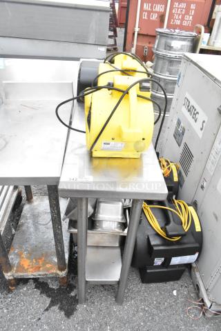 Stainless steel table with metal under shelf and back splash, including two Dayton air mover fans, slightly worn condition.