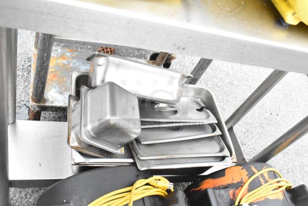 Stainless steel table with metal under shelf and back splash, includes 2 Dayton air mover fans, in used condition.