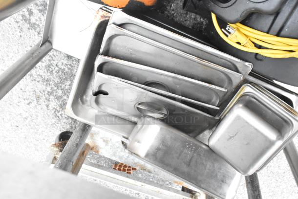 Stainless steel table with metal under shelf and back splash, includes two Dayton air mover fans, pans and accessories visible.