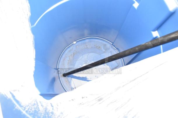 Blue container interior with a black rod inside. The rim and exterior details are obscured by white material.