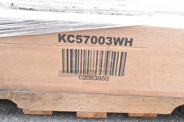 Cardboard box with printed code "KC57003WH" and barcode "02063850," containing dining table. Scratch and dent lot.