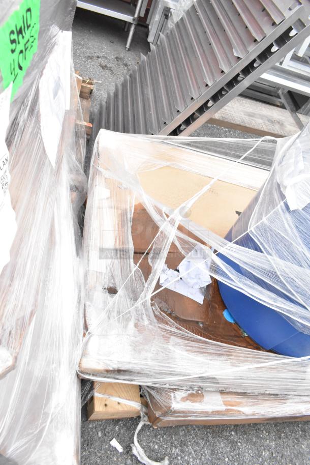 Pallet of wrapped items including Aarco message center and dining table in scratch and dent condition, tags visible.