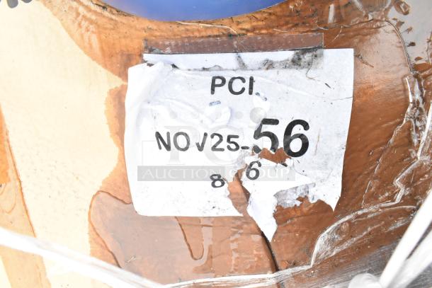 Torn label showing the text "PCI NOV 25 56" on a scratched brown surface, partial text visible.