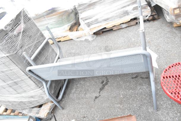 Red mesh table and two gray mesh benches with durable metal frames, outdoor use, minor wear visible.