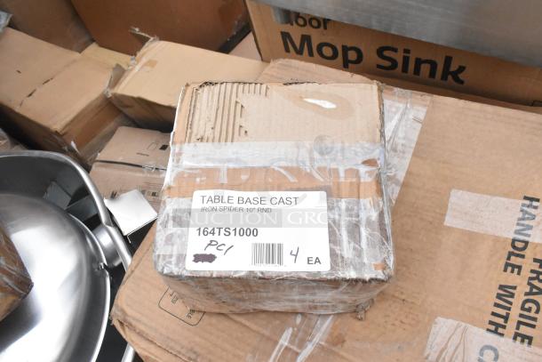 Box labeled "Table Base Cast, Iron Spider 10'' RND, 164TS1000, 4 EA" atop cardboard, with metal sink visible.