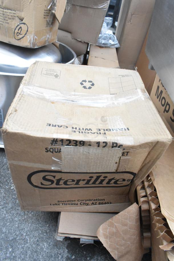 Cardboard box labeled "Sterilite," containing 8 new items with minor scratches and dents. Includes salad bowls, concrete level, sink, and mop sink.