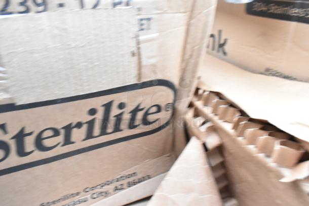Cardboard boxes labeled "Sterilite" containing new scratch-and-dent items including salad bowls and sinks.
