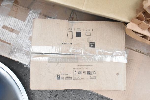 Cardboard box labeled "8 Brand New Scratch and Dent." Contains various items including salad bowls, concrete level, sink, and mop sink.