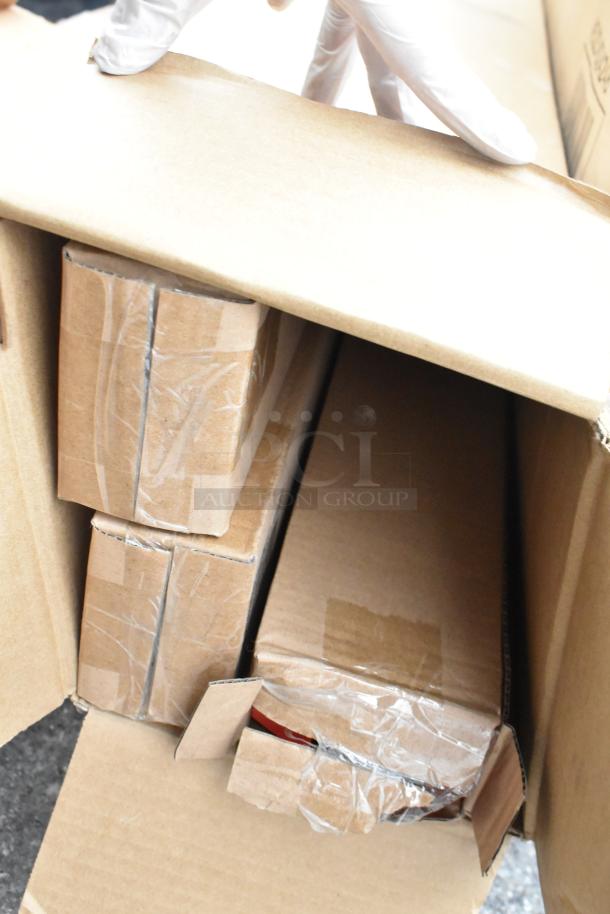 Cardboard boxes containing scratch and dent items, including salad bowls and sinks, viewed from the top.