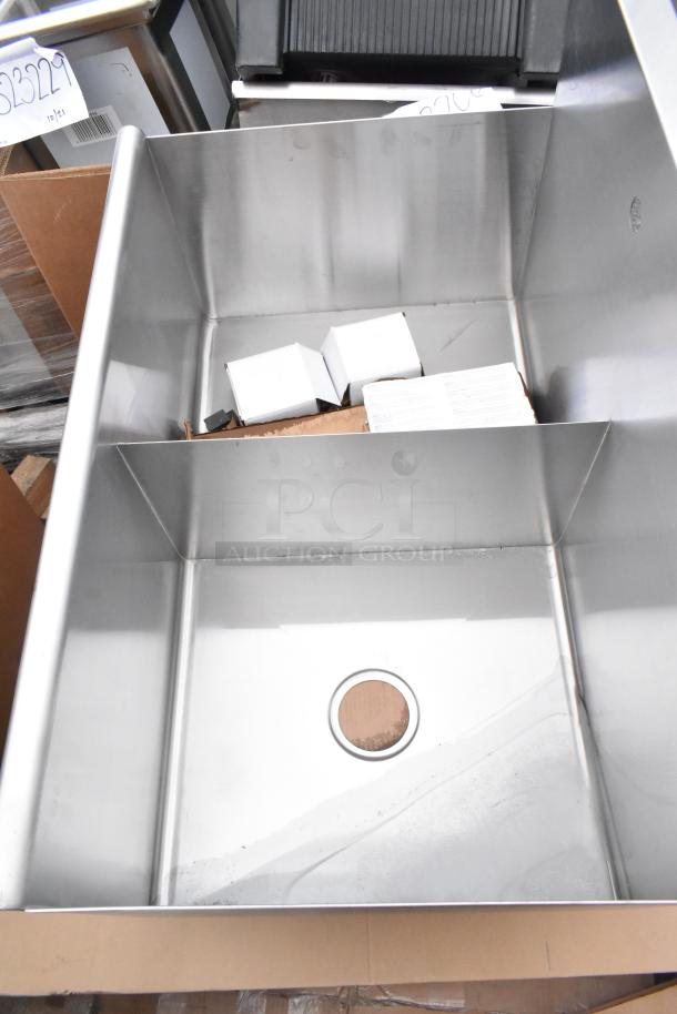 Stainless steel mop sink, new, with drain opening. Includes additional boxed items. Part of an 8-item auction lot.