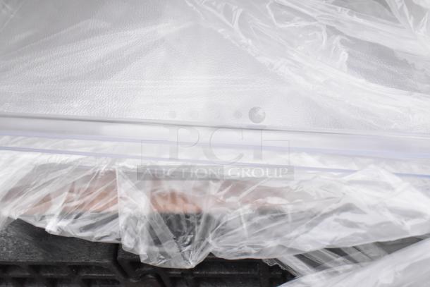 Eight brand new scratch and dent items wrapped in plastic, including sink, mop sink, dolly.