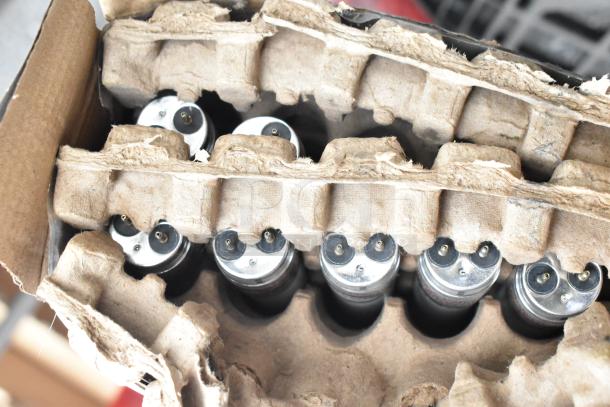 Cardboard pack with multiple LED light units, metal prong connectors visible; part of auction item set with tables.