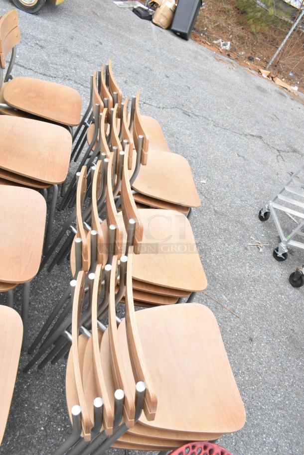 Set of 30 dining height chairs with wood pattern seats on chrome finish frames, stacked, in good condition.