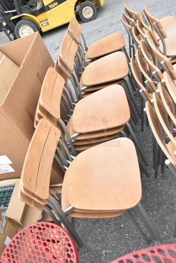 30 wood pattern dining height chairs with chrome finish frames, in good condition, stacked for auction.