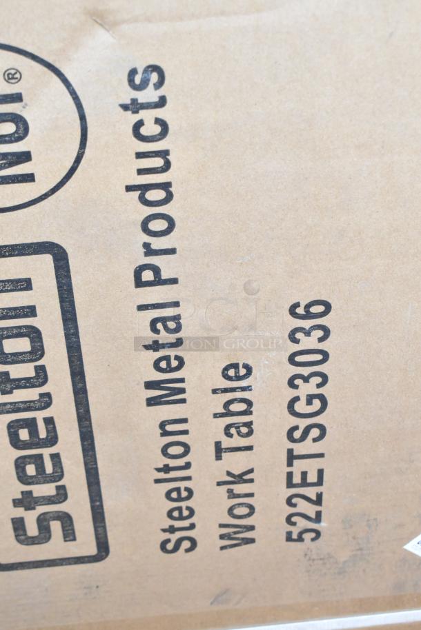 Steelton 522ETSG3036 label on cardboard, indicating a 30"x36" 18 gauge 430 stainless steel work table with undershelf.