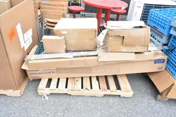 Six brand new scratch and dent items, including dish caddies, in boxes on a pallet. Utility Wire Shelf Kit visible label.