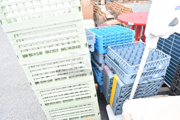 Lot of dish caddies and various items, including stacked green and blue racks, in used condition. Ideal for storage or catering.