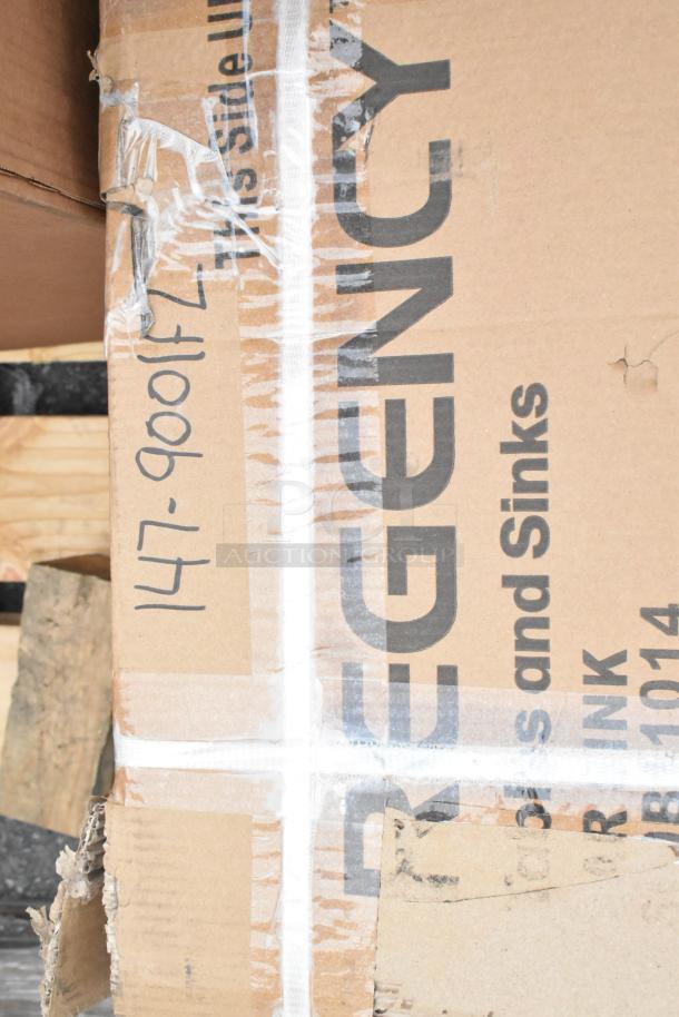 Cardboard box with "Regency" label, showing product includes sinks. Box has visible wear and handwritten code.