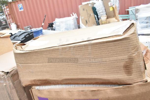 Cardboard boxes showing signs of wear, containing brand new scratch and dent items like boiler grate and door gasket.