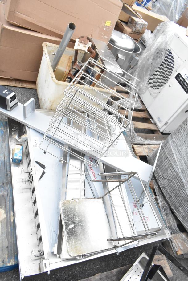 Pallet lot of various items including stainless steel pieces and a metal rack. Mixed condition, ideal for resale or parts.