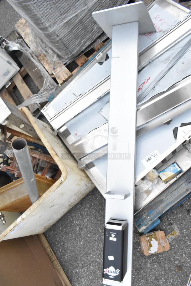 Pallet of mixed items including stainless steel pieces, a metal rack, and a Germ-X dispenser. Items appear used.