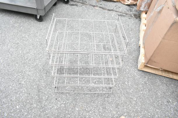 Pallet lot containing stainless steel wireframe basket and cardboard box, placed on asphalt.