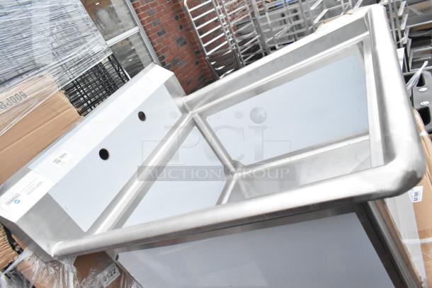 Brand new metal sink with potential scratch or dent, stainless steel construction, visible labels, set against industrial background.