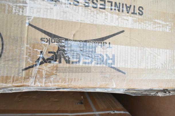 Cardboard box displaying "Regency Tables and Sinks" branding. Contains new scratch and dent items like wire shelves, sink, and drawer.