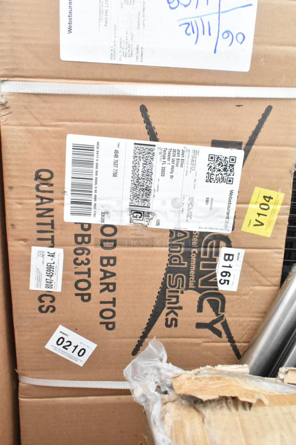 Cardboard box labeled "Stainless Steel Commercial and Sinks" with packing labels and codes. Contains new scratch and dent items.