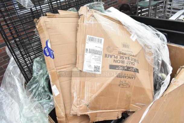 Damaged boxes showing wire shelves, sink, and drawer. Labels indicate "Cast Iron Table Base Plate 30" x 30"." Items appear new.
