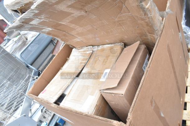 Large cardboard box containing 6 brand new scratch and dent items, including a host station and dispenser, on a pallet.