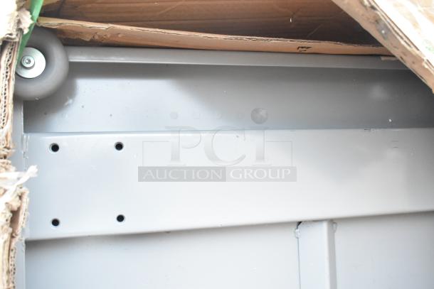 Brand new metal item with minor scratches, featuring a wheel and various mounting holes. Part of a 6-piece auction.