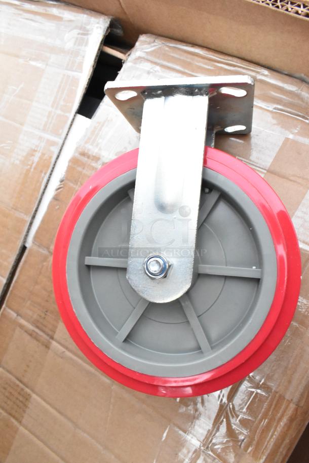 Red and gray caster wheel attached to a metal bracket on a cardboard surface. Part of a lot including host station, dispenser.